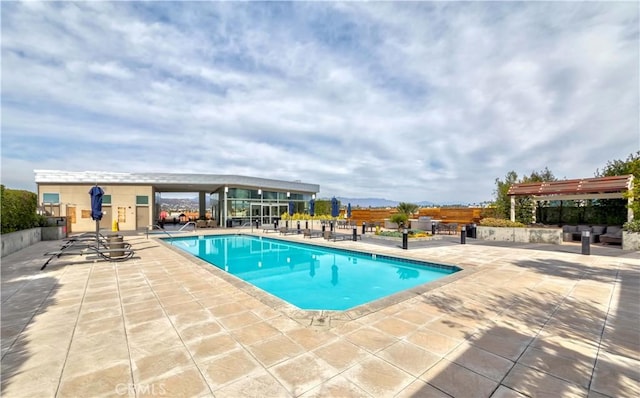 outdoor pool with a patio area and a pergola