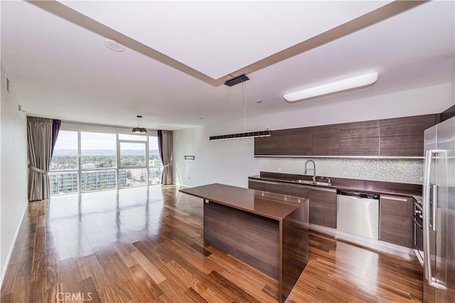 kitchen with stainless steel appliances, wood finished floors, decorative backsplash, a center island, and modern cabinets