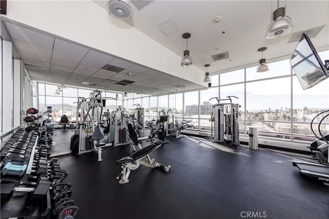 workout area featuring visible vents and a wall of windows