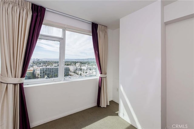 spare room with carpet and baseboards