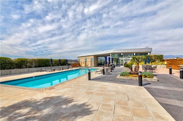 pool featuring fence and a patio