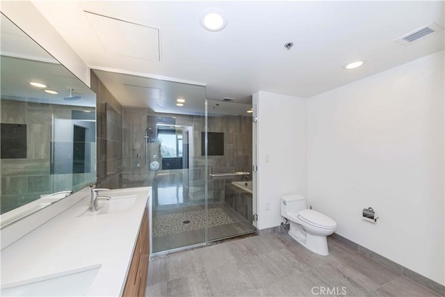 bathroom featuring toilet, a sink, visible vents, a shower stall, and double vanity