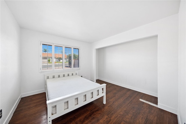 bedroom with wood finished floors and baseboards