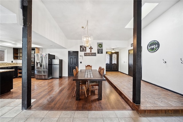 dining space with light wood-type flooring and a notable chandelier