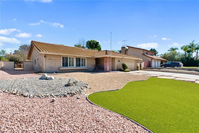 ranch-style home with concrete driveway, a tile roof, and an attached garage