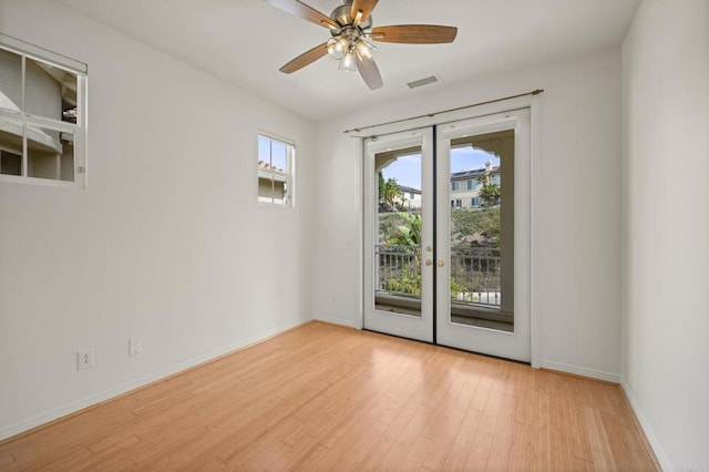 spare room featuring baseboards, visible vents, wood finished floors, and french doors