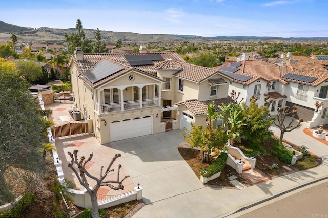 view of front of home with solar panels, a gate, fence, a residential view, and driveway