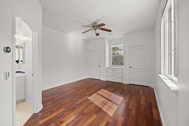 spare room with ceiling fan, hardwood / wood-style floors, arched walkways, and baseboards