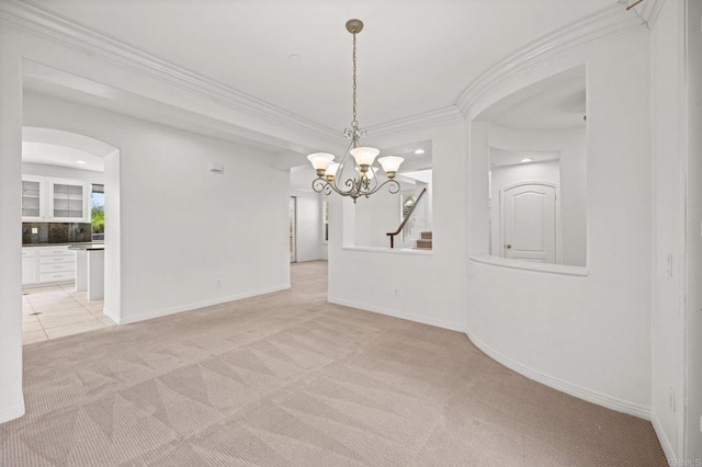 spare room featuring light colored carpet, crown molding, and baseboards