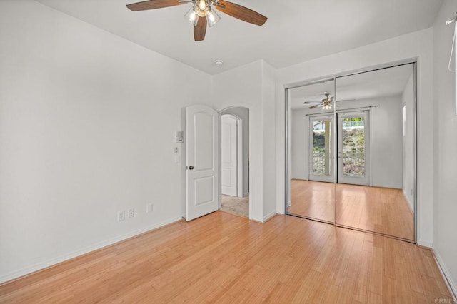 spare room with baseboards and wood finished floors