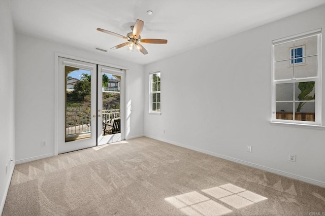 spare room featuring baseboards, visible vents, a ceiling fan, carpet flooring, and french doors