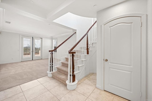 carpeted entrance foyer featuring stairs, french doors, tile patterned flooring, and ornamental molding