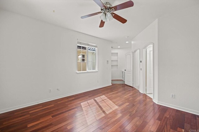 spare room with wood-type flooring, baseboards, and ceiling fan