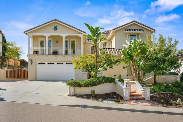 view of front of home featuring a garage, a gate, concrete driveway, and stucco siding