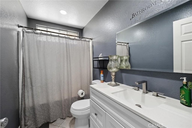 bathroom featuring a textured wall, toilet, a textured ceiling, vanity, and tile patterned floors