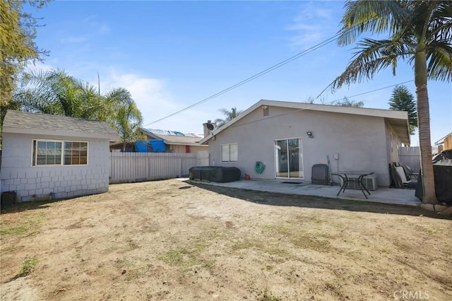 rear view of house with a patio and a fenced backyard