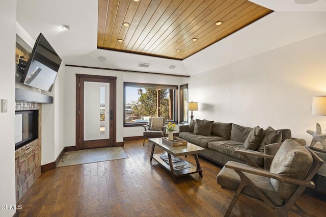 living room featuring a tray ceiling, a fireplace, visible vents, wood ceiling, and hardwood / wood-style flooring