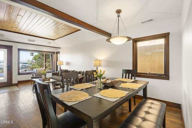 dining room featuring hardwood / wood-style flooring, baseboards, visible vents, and beam ceiling