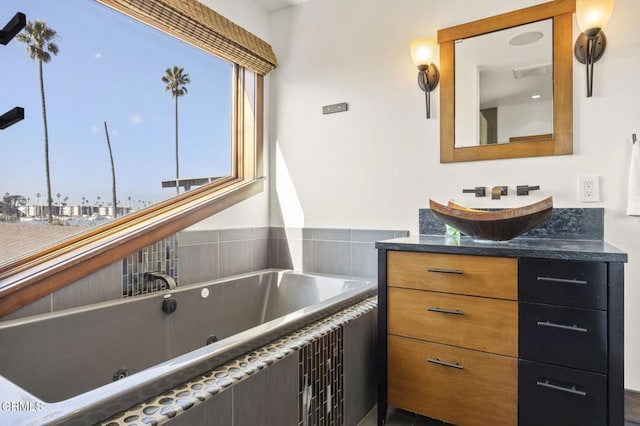 bathroom with a whirlpool tub, visible vents, and vanity