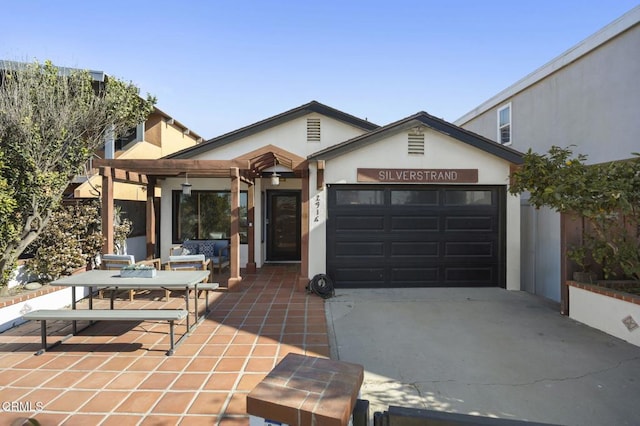 view of front of property with concrete driveway, an attached garage, and stucco siding