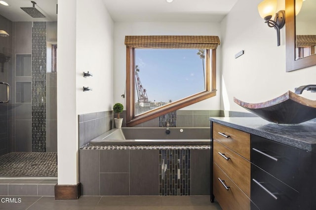 bathroom featuring a bath, tile patterned flooring, a shower stall, and vanity