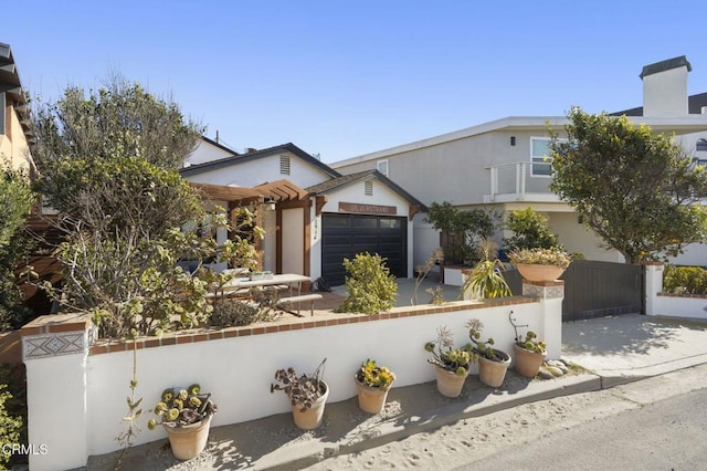 view of front of property featuring fence, driveway, an attached garage, and a pergola