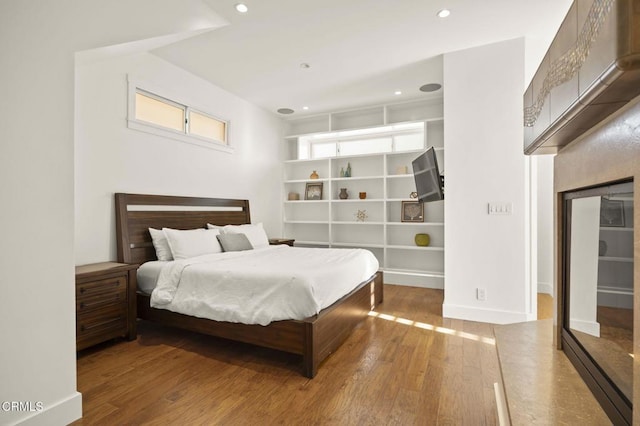 bedroom with baseboards, wood-type flooring, and recessed lighting