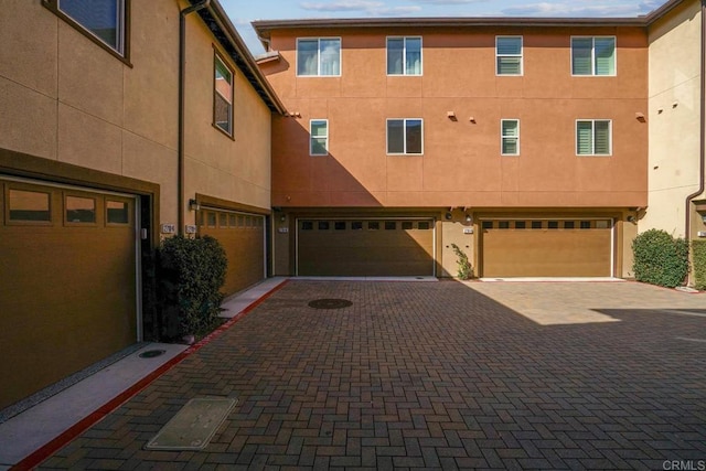 exterior space featuring driveway, a garage, and stucco siding