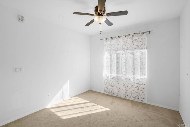 spare room with carpet and a ceiling fan