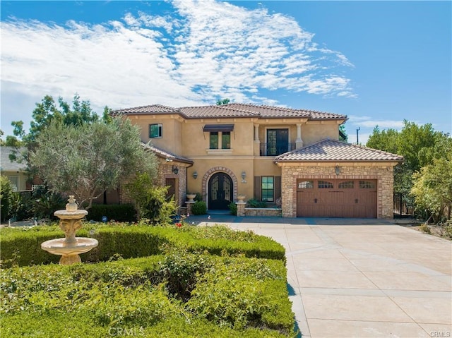 mediterranean / spanish-style house featuring a garage, driveway, a tiled roof, and stucco siding