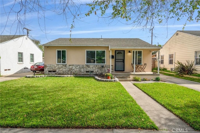 single story home featuring roof with shingles, stucco siding, a porch, a front yard, and stone siding