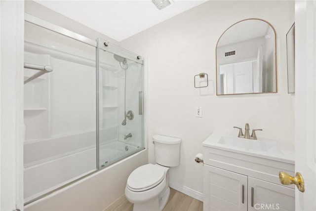 full bathroom featuring visible vents, toilet, enclosed tub / shower combo, vanity, and wood finished floors