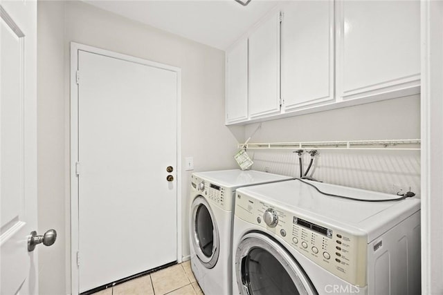 laundry room with light tile patterned floors, cabinet space, and separate washer and dryer