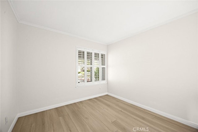 unfurnished room featuring light wood-style floors, baseboards, and ornamental molding