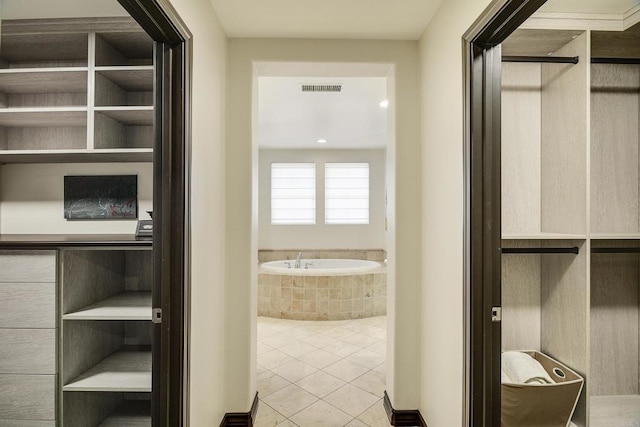 bathroom with tile patterned floors, visible vents, and a bath