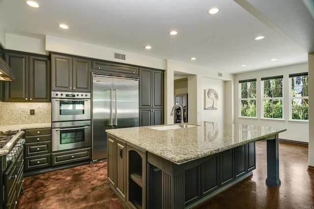 kitchen with light stone counters, visible vents, a sink, appliances with stainless steel finishes, and tasteful backsplash