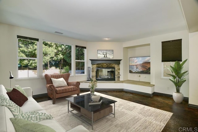 living room featuring a fireplace, visible vents, and baseboards