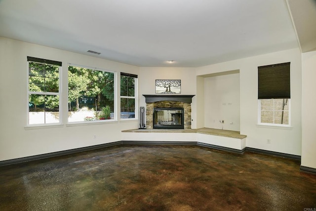 unfurnished living room featuring a fireplace, visible vents, concrete floors, and baseboards