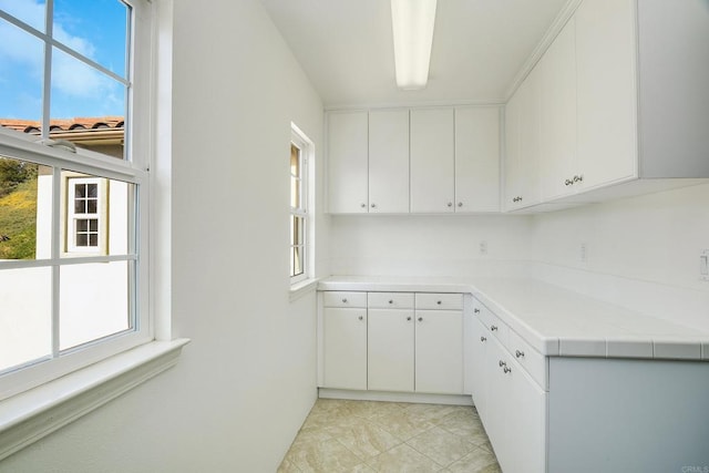 kitchen featuring white cabinetry, light countertops, and light tile patterned flooring