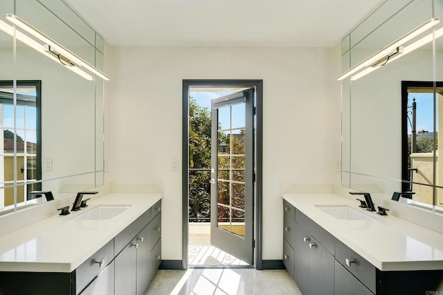 bathroom with a sink, baseboards, and two vanities