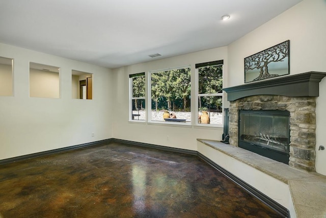 unfurnished living room featuring visible vents, a fireplace, baseboards, and concrete floors