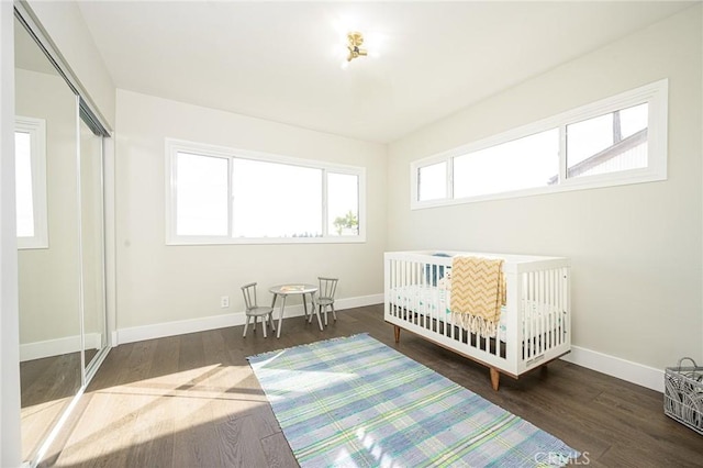 bedroom featuring a closet, wood finished floors, and baseboards