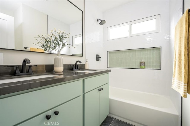 bathroom featuring double vanity, a sink, washtub / shower combination, and tile patterned floors