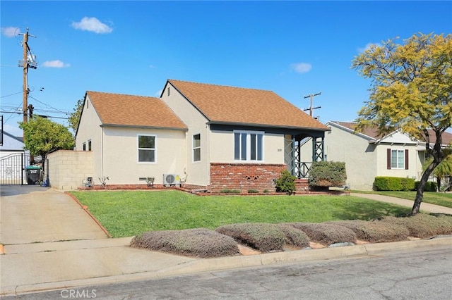 view of front of property with driveway, brick siding, roof with shingles, a front lawn, and stucco siding