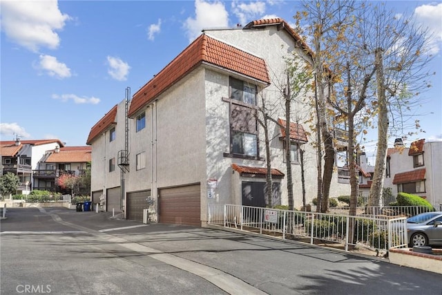 view of building exterior with an attached garage and a residential view