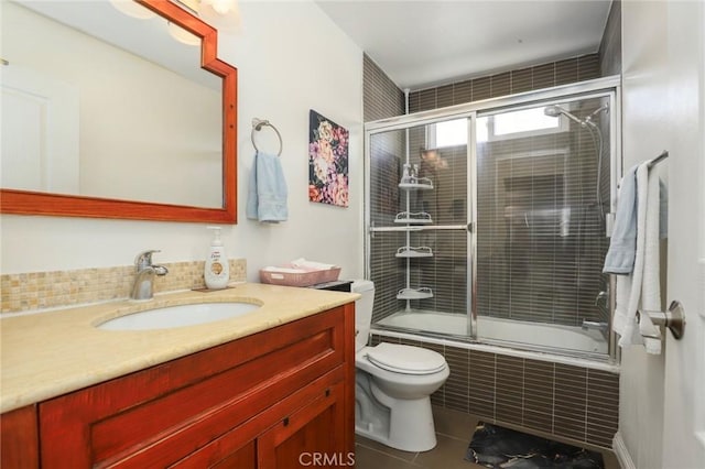 bathroom with tiled shower / bath, vanity, toilet, and tile patterned floors