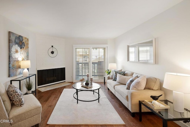 living room with dark wood-type flooring and a fireplace