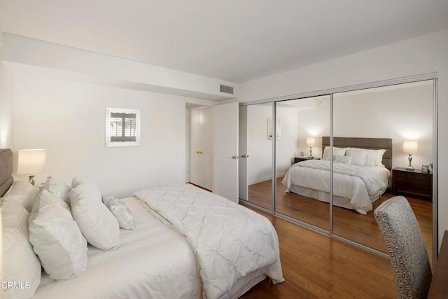 bedroom featuring a closet, visible vents, and wood finished floors