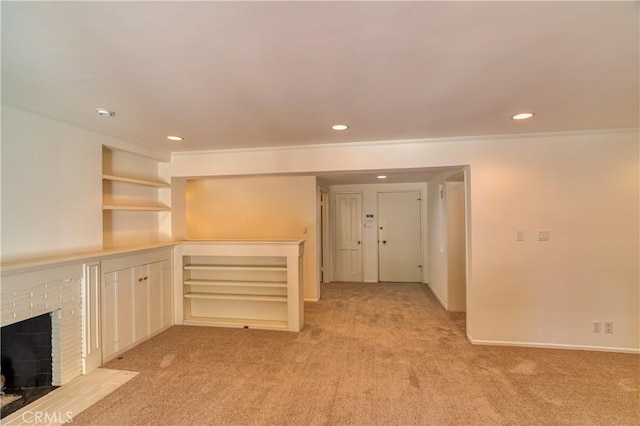 unfurnished living room featuring recessed lighting, a brick fireplace, light colored carpet, and baseboards