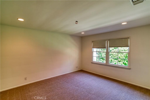 empty room with baseboards, visible vents, dark carpet, and recessed lighting